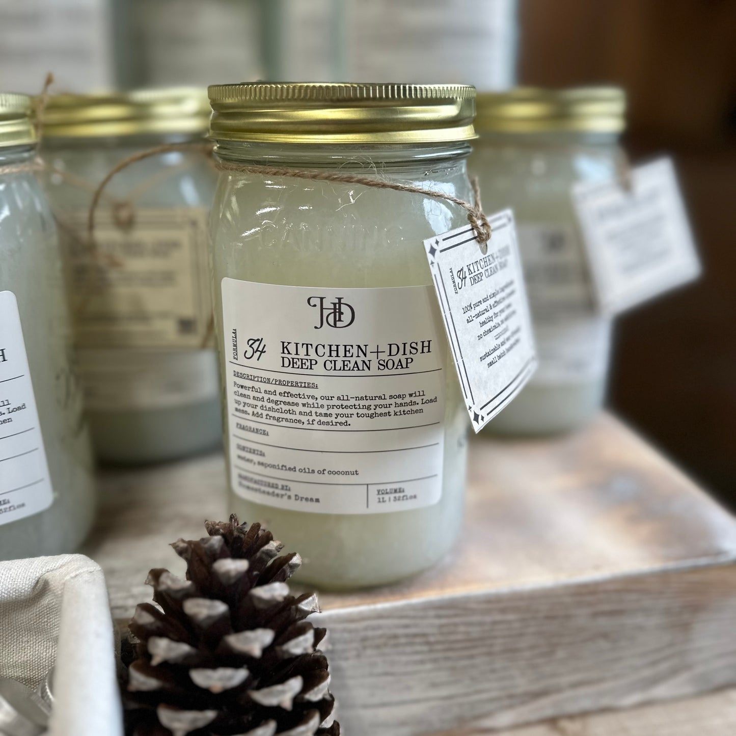 kitchen and dish soap is an all-natural option to deep clean, beautiful quart jars stacked on wood with a pinecone decoration