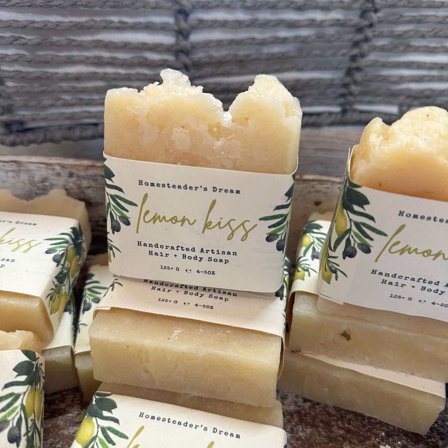 Handcrafted lemon-scented soap bars with linen paper labels on a wooden box.