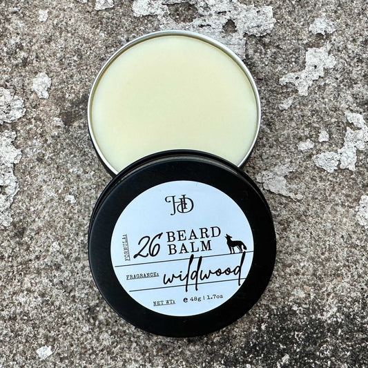 Beard balm tin with open lid on a textured surface