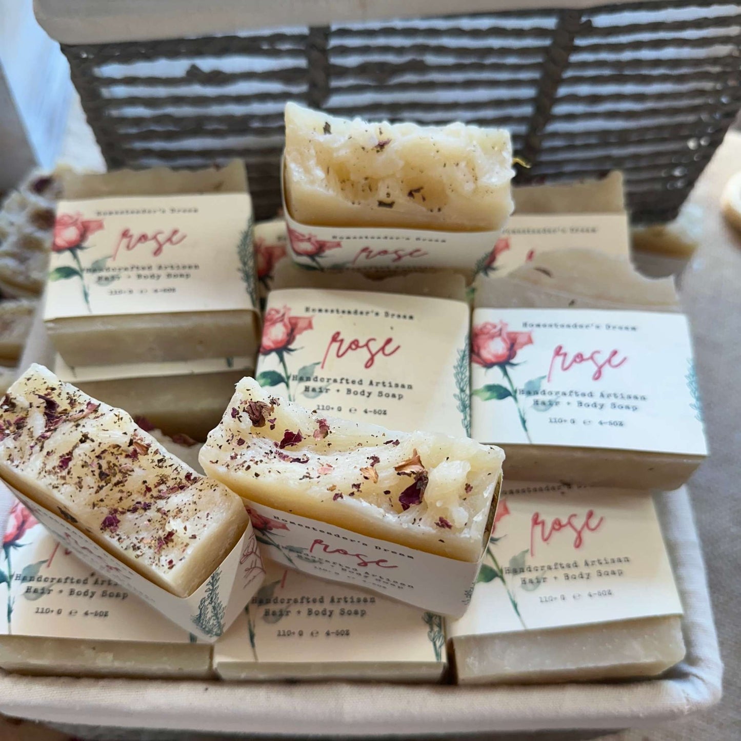 romantic rose handcrafted artisan soap bars in a woven basket with real roses on top of the bars