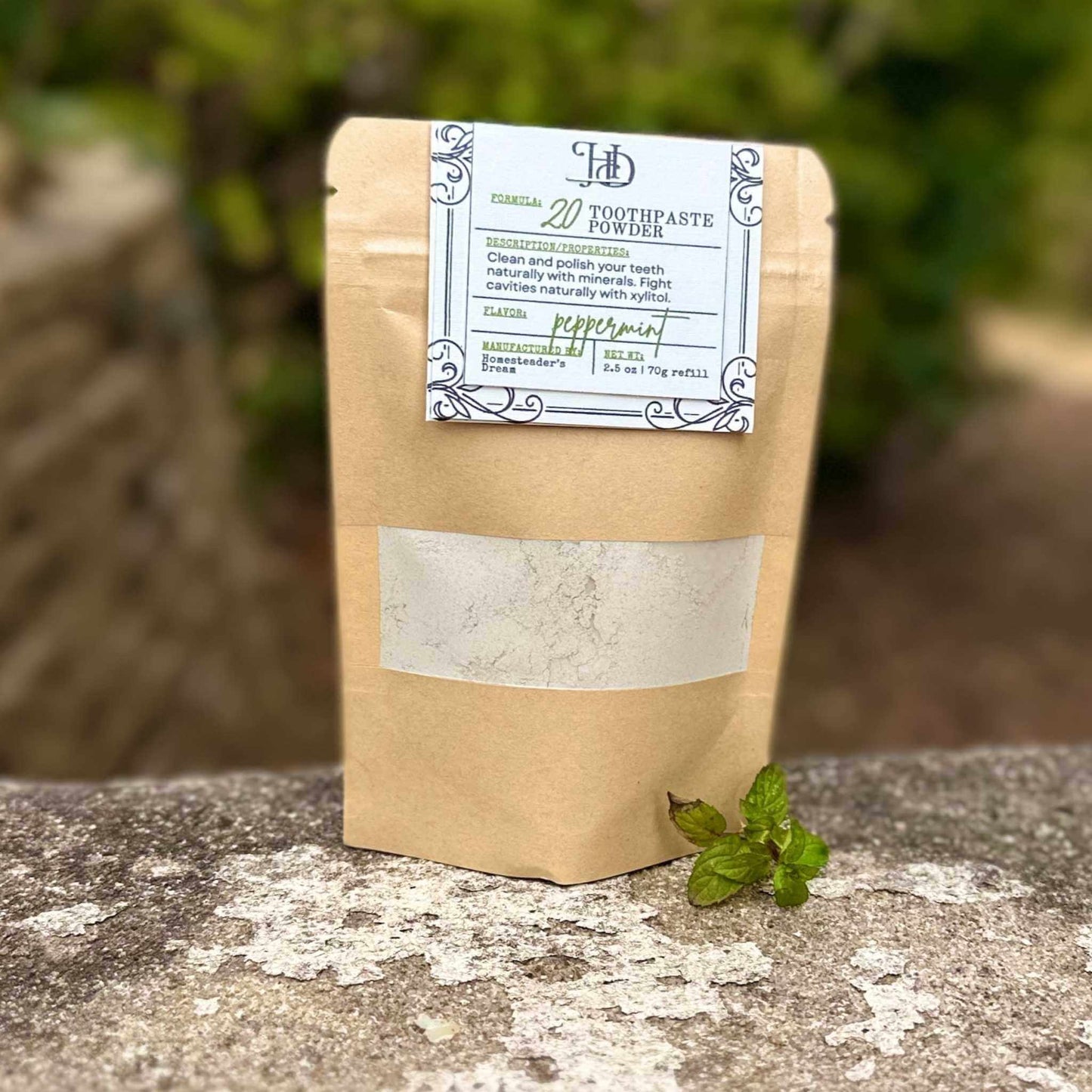 Kraft paper packaging of toothpaste powder with a label on a stone surface.