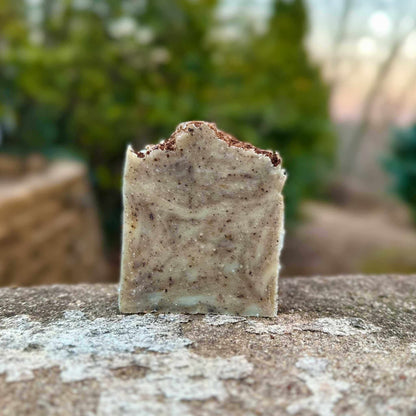 Bar of soap with a textured surface on a stone surface outdoors