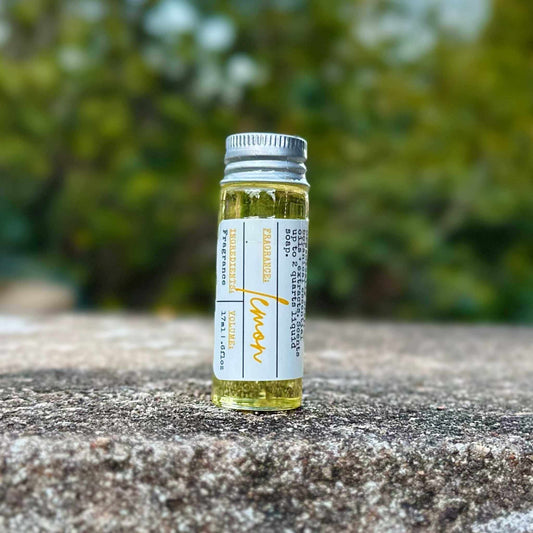 Small bottle of lemon scent on a stone surface with a blurred green background