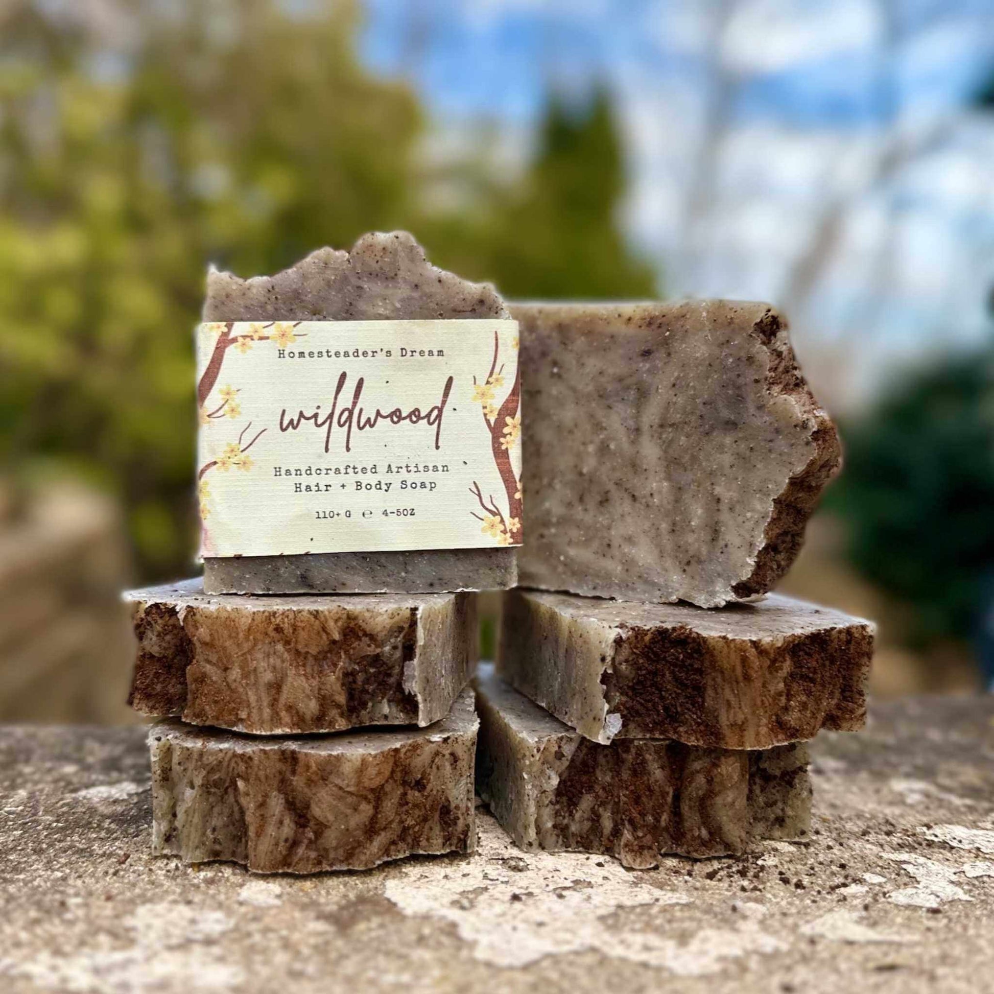 Stack of handmade soap bars with a 'wildwood' label against a natural background