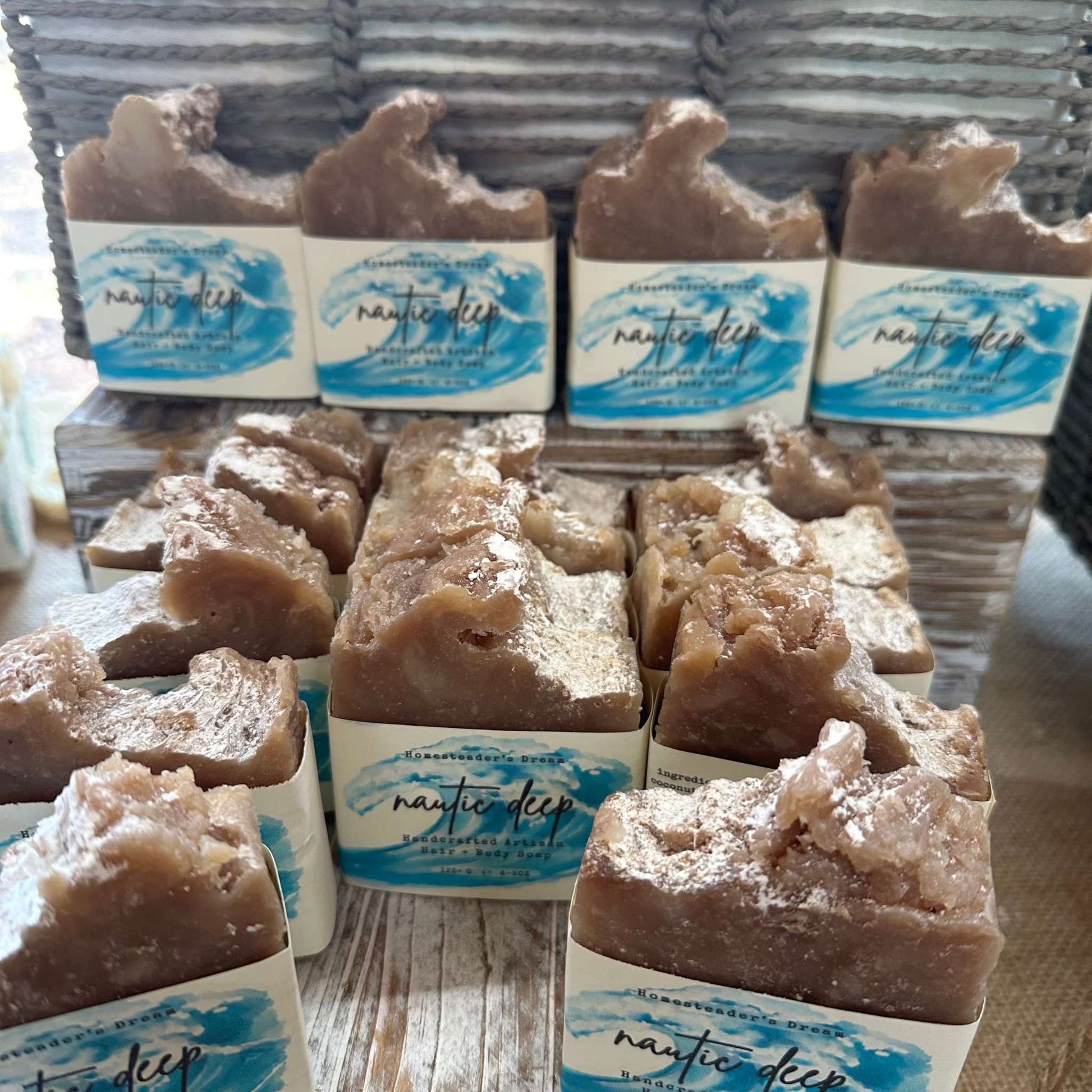 artisan bars of soap shaped like a wave with 'nautic deep' branding on a wooden surface