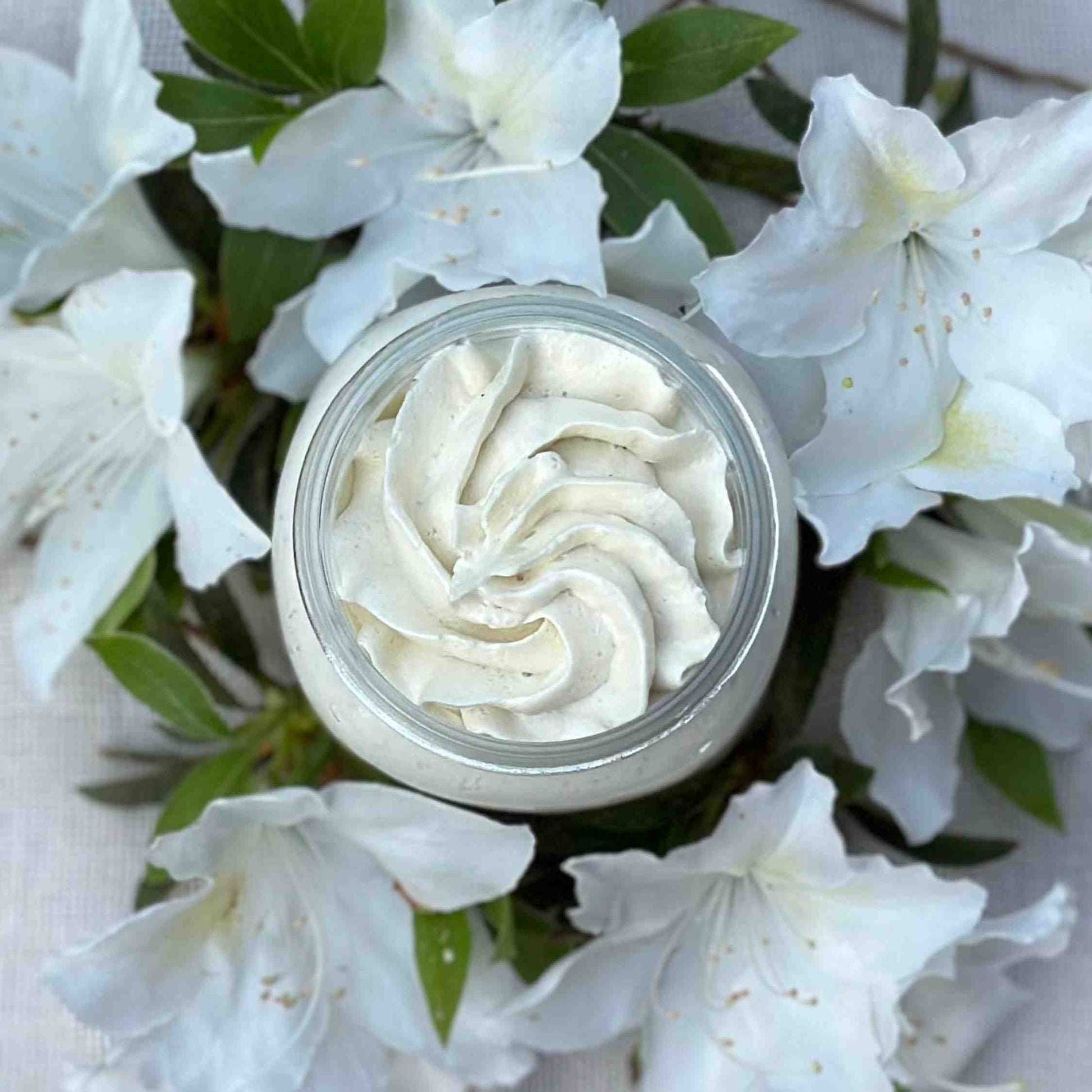 serenity unscented body butter with swirled top surrounded by white flowers