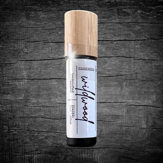 Roll-on cologne bottle with wooden cap on a dark wooden surface