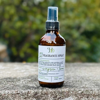 Fragrance spray bottle with label on a stone surface with a blurred green background