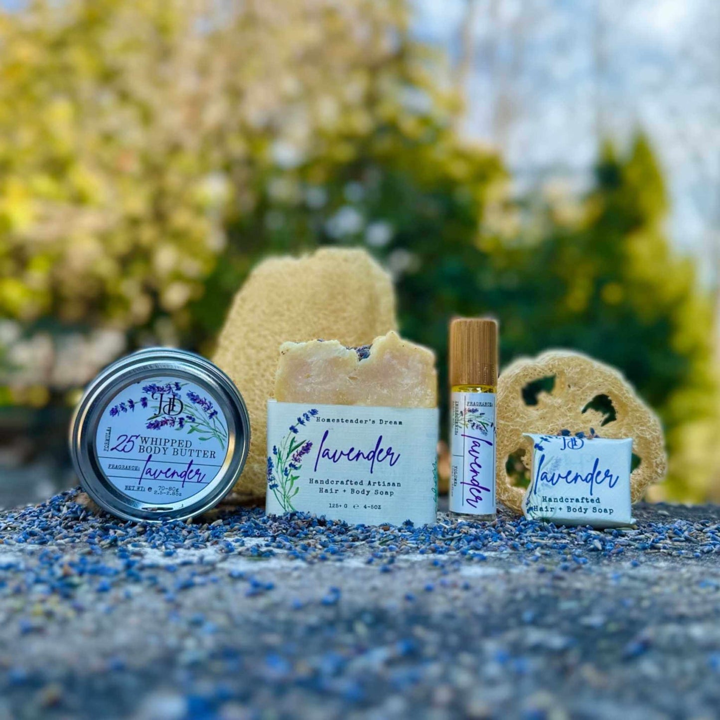 Lavender-themed skincare products including a jar, bar of soap, and roller bottle on a natural background.