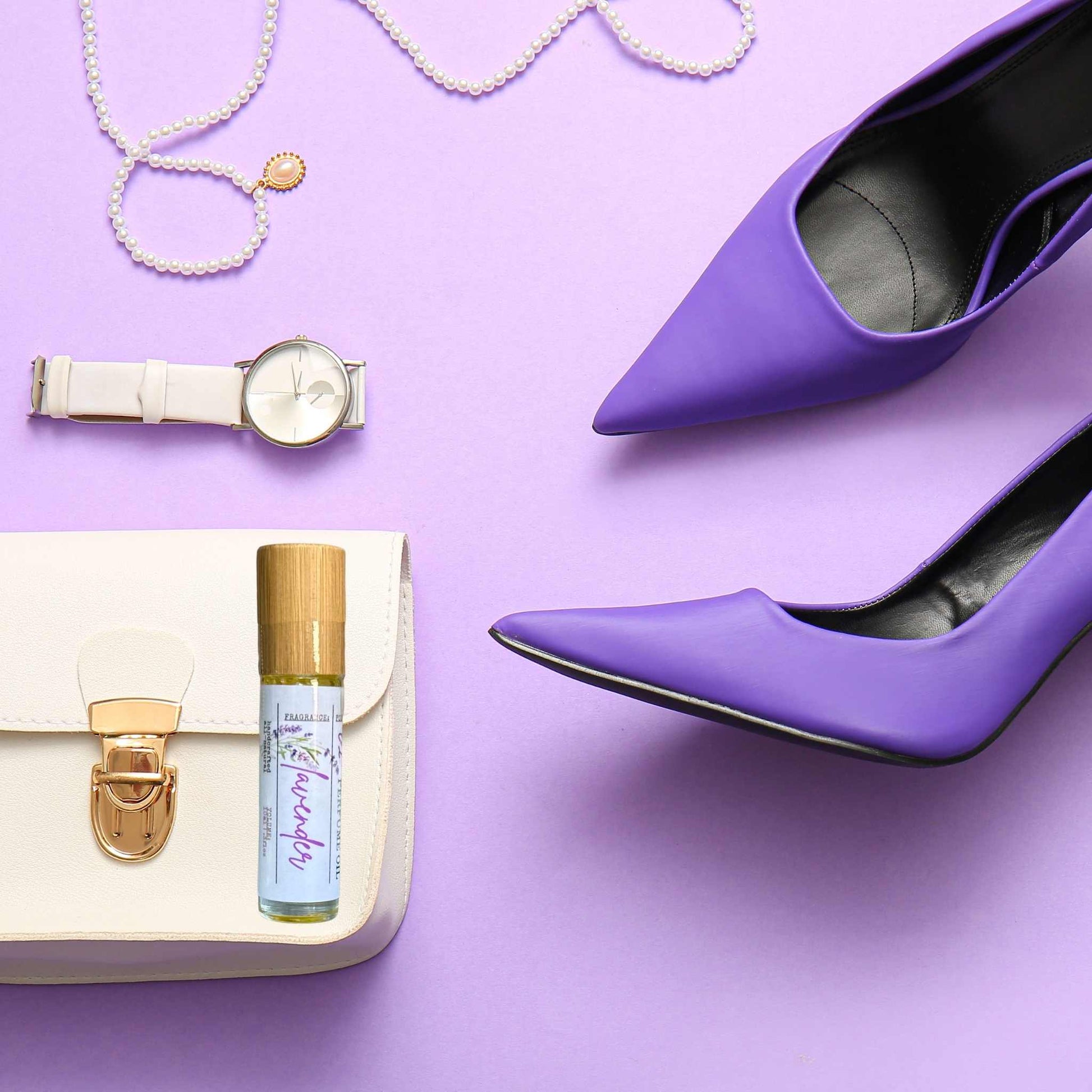 Purple high heels, watch, handbag, and jewelry on a purple background