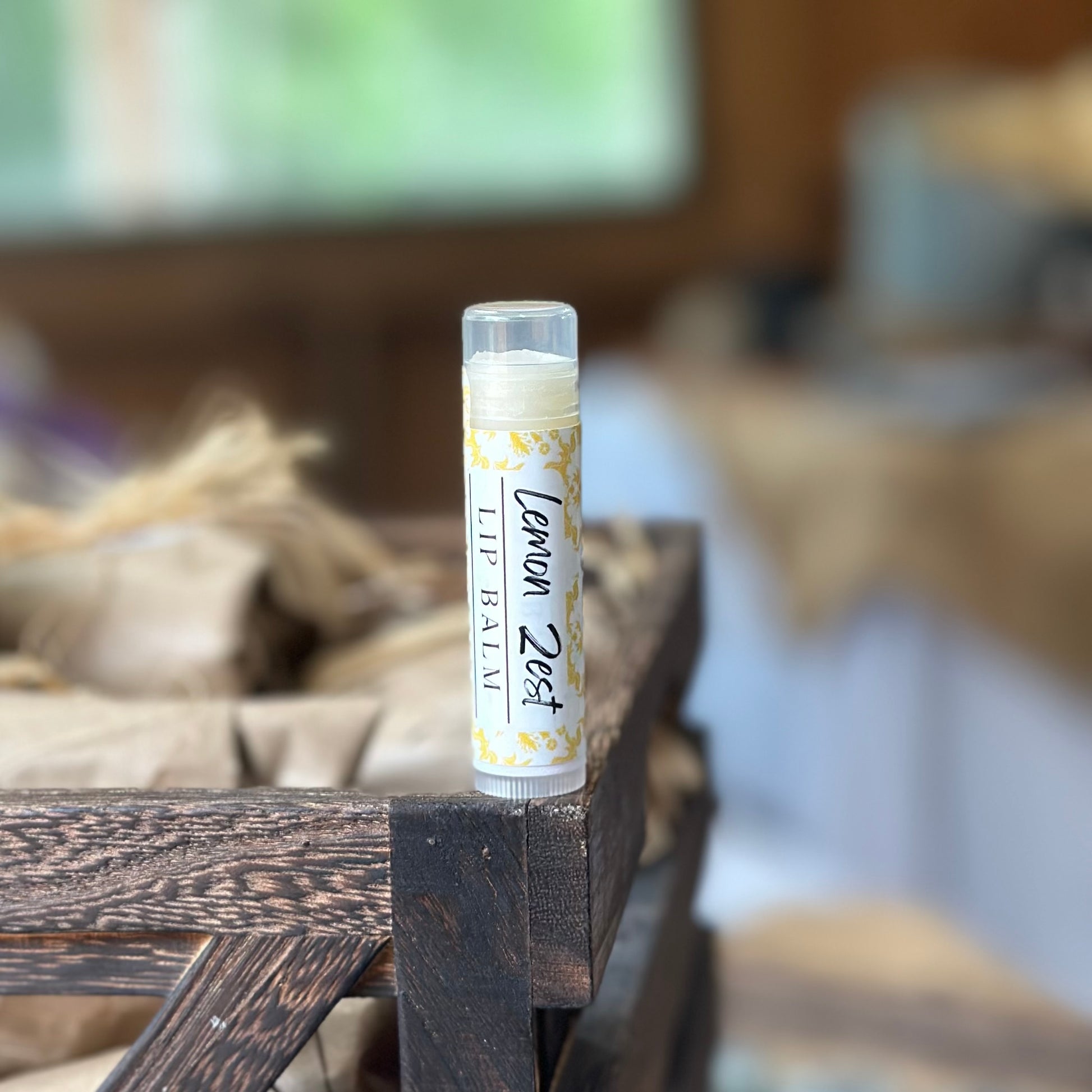 lemon zest lip balm on wooden crate with blurred background
