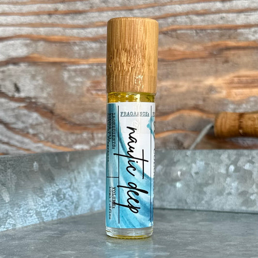 Roll-on cologne bottle labeled 'Nautic Deep' with a bamboo cap on a rustic background.