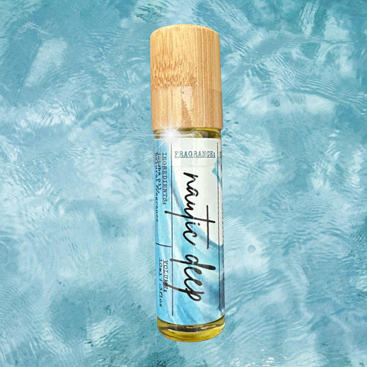 Roll-on cologne bottle with wooden cap on a textured blue background