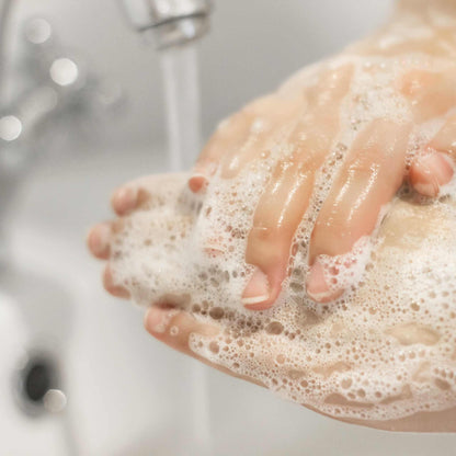 Hands being washed with soap under running water with rich lather