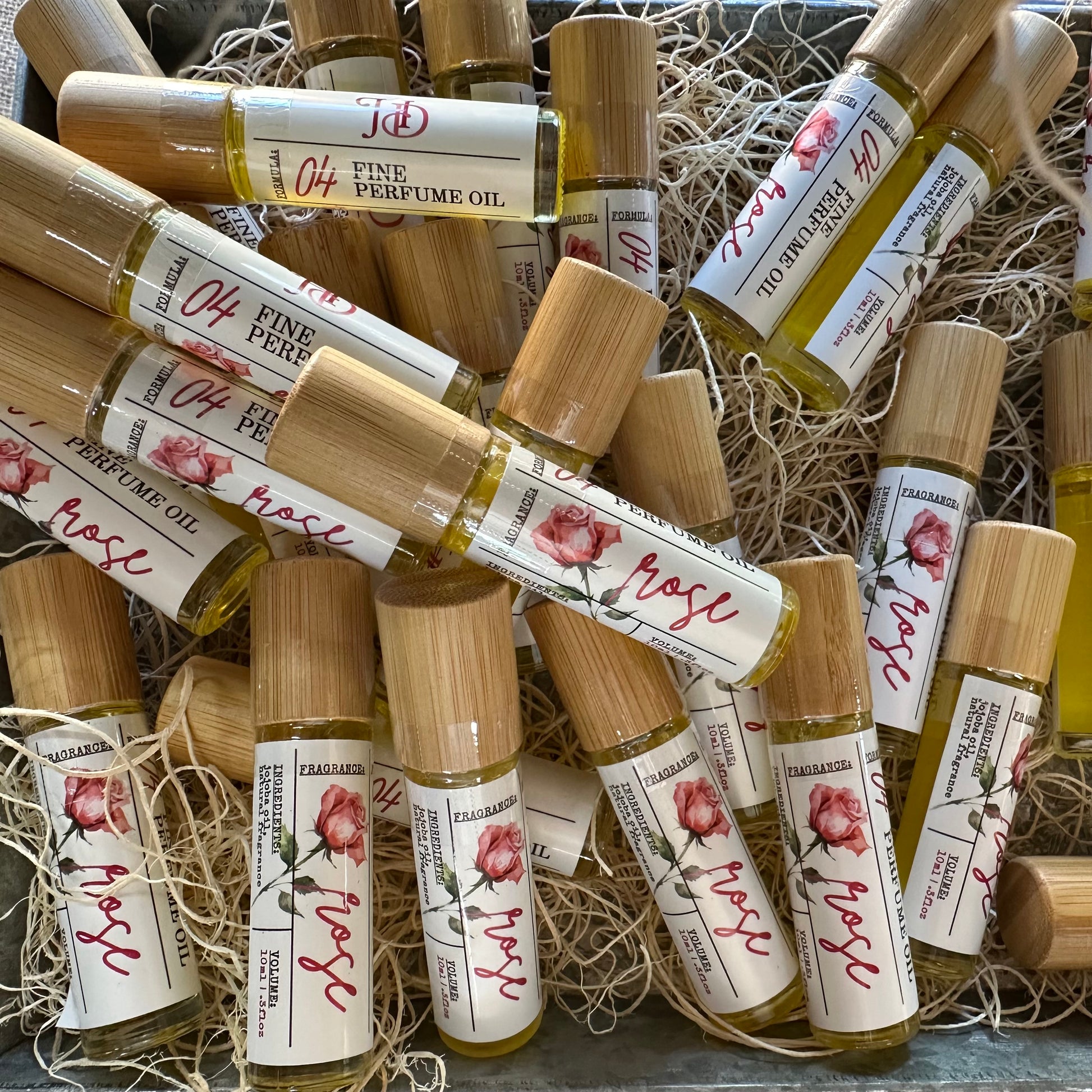 Collection of small perfume bottles with wooden caps on a textured surface