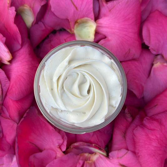 top view of rose piping into body butter jar on a bed of pink petals