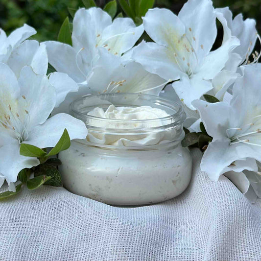 serenity unscented body butter front view of jar surrounded by white flowers