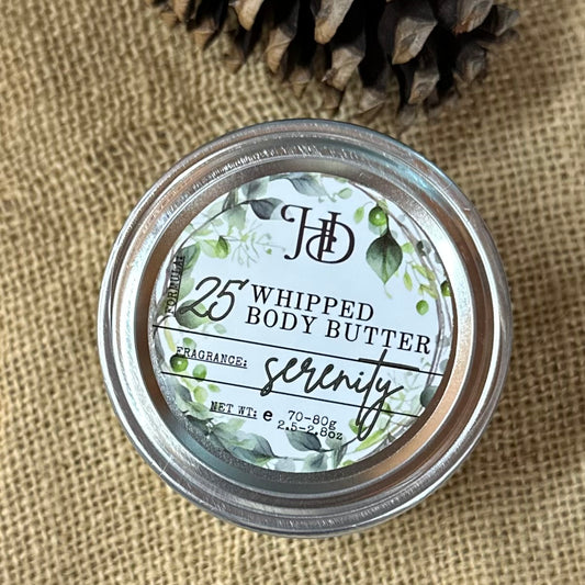 Jar of whipped body butter labeled 'Serenity' on a textured fabric background