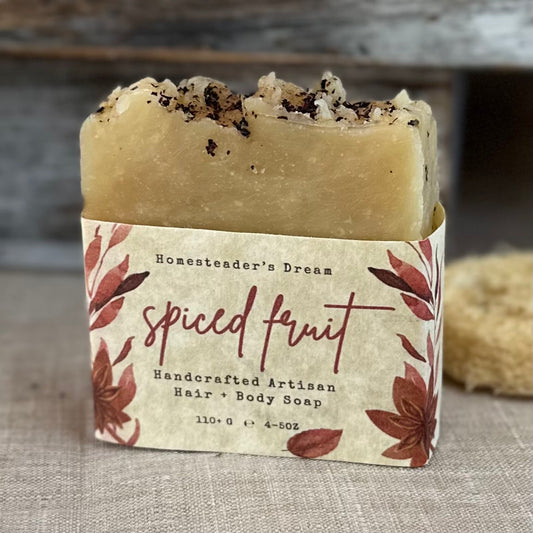 Handcrafted artisan soap bar with 'Spiced Fruit' label on a textured surface