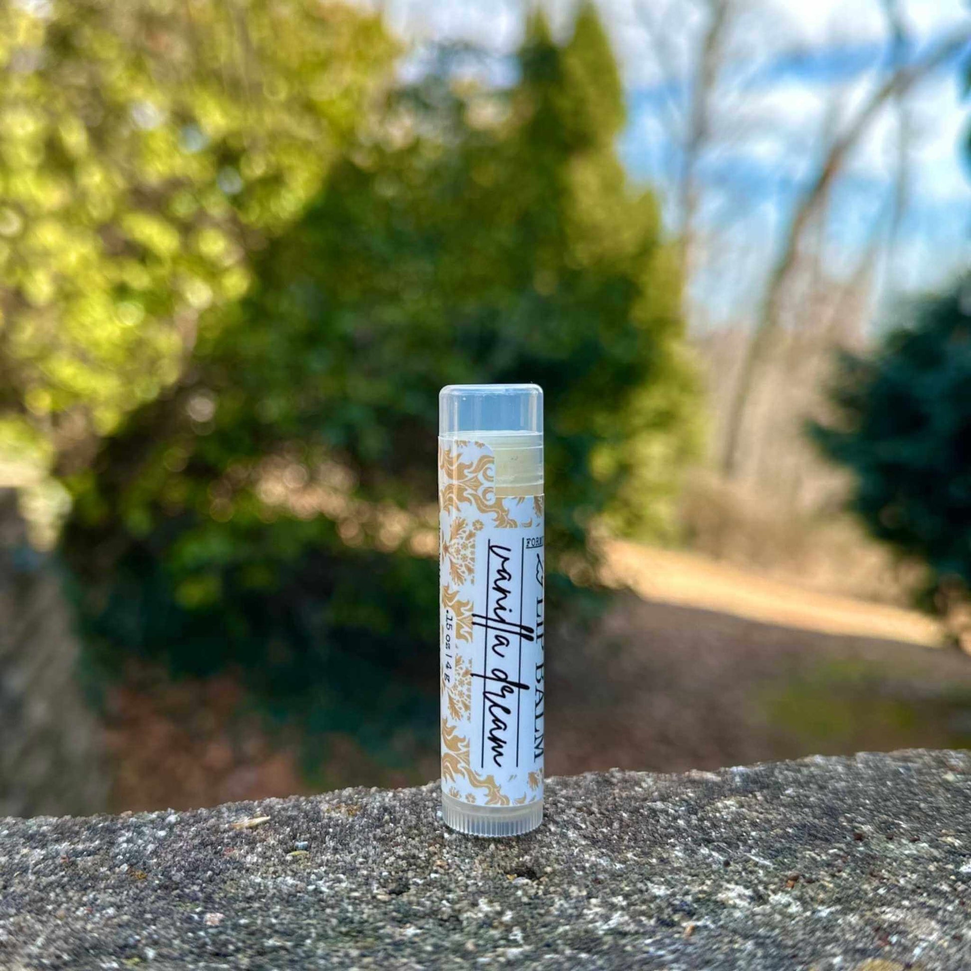 tube of vanilla lip balm on a stone surface with a blurred natural background